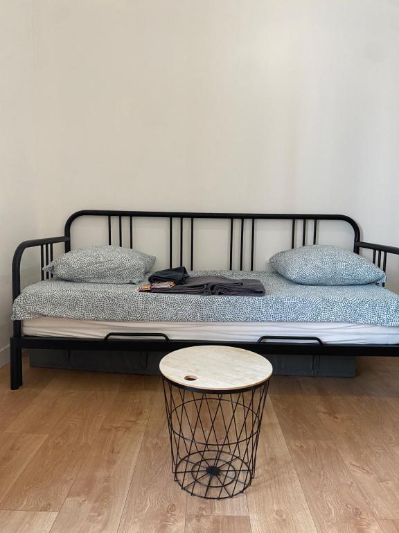 cama con marco negro y mesa en LA MAISON D'ANTONIN 2 en Nimes