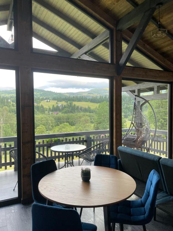 een kamer met tafels en stoelen en een groot raam bij Tiny House Todireni in Vatra Dornei