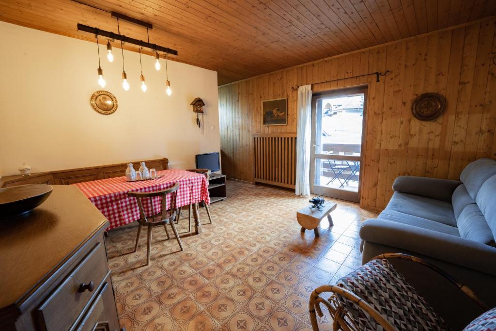 een woonkamer met een blauwe bank en een tafel bij La Finestra sui Monti - Alpine Stay Apartments in Cavalese