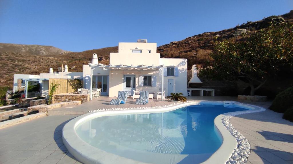 a white villa with a swimming pool in front of it at The Sundown Villa in Parasporos