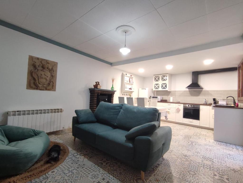 a living room with a couch and a kitchen at Casa Rural La Gineta in Calaceite