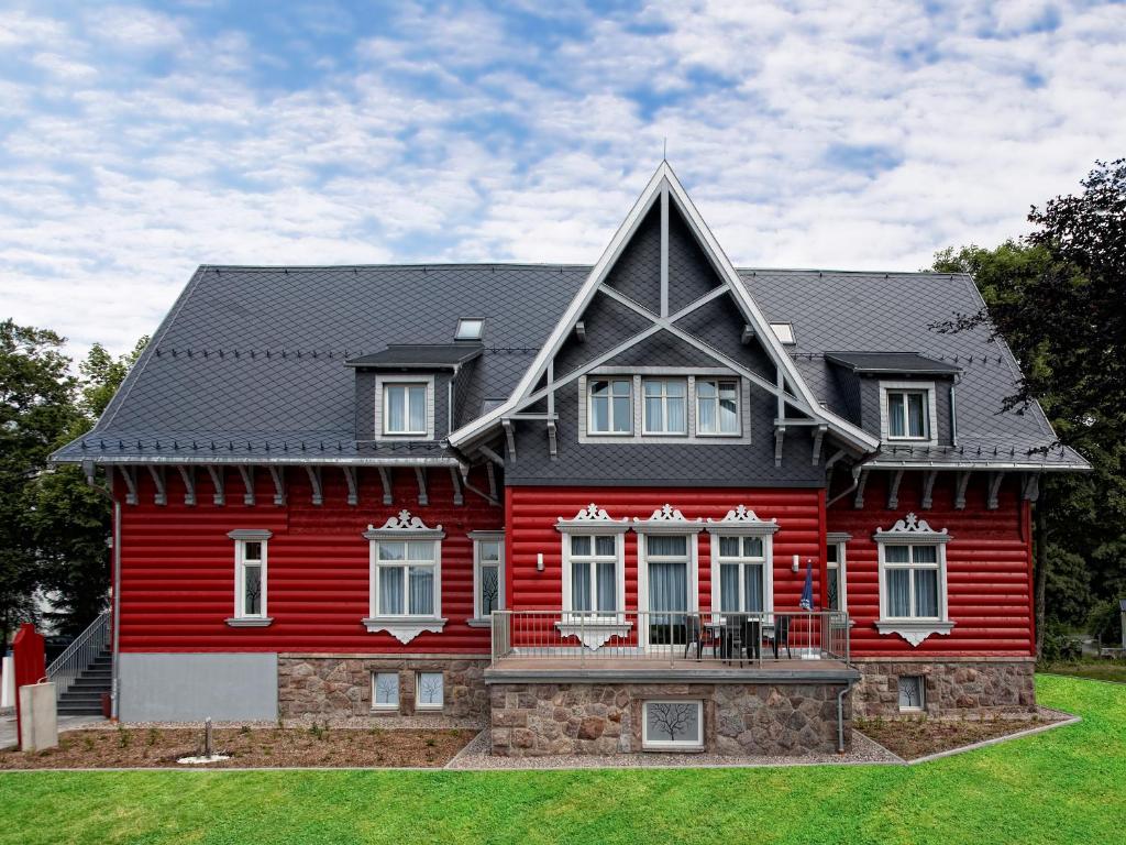 una casa rossa con tetto nero di Villa Silva - Oberhof - Nebenhaus Berghotel Oberhof - nur Übernachtung a Oberhof