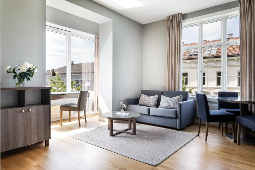 ein Wohnzimmer mit einem blauen Sofa und einem Tisch in der Unterkunft Frogner House - Oscars gate in Oslo