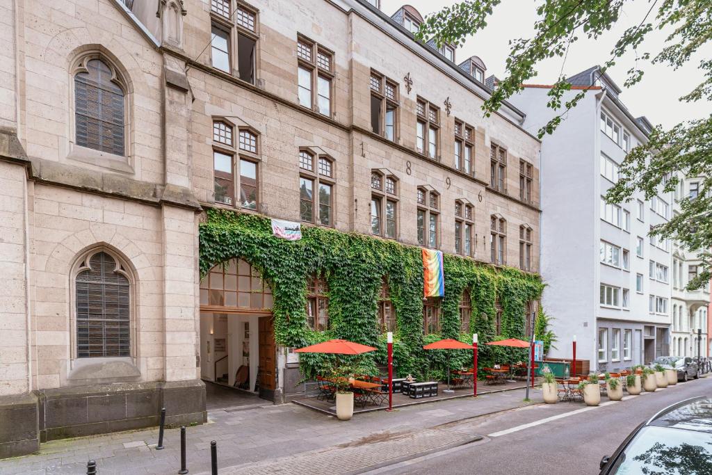 a building with green ivy on the side of it at Tagungs und Gästehaus St Georg in Cologne