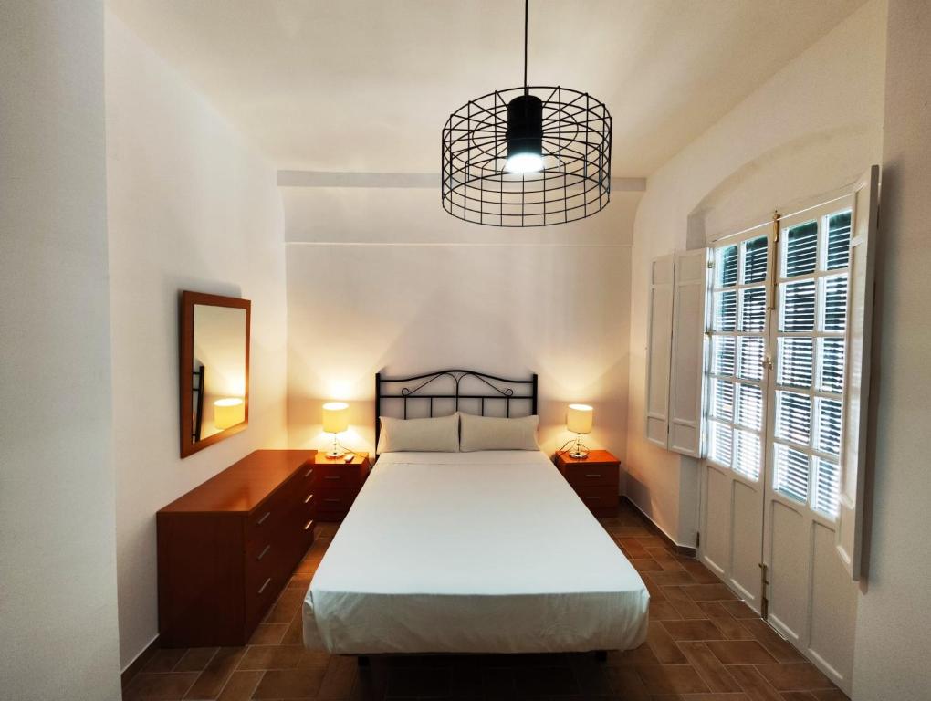 um quarto com uma cama e um lustre em Casa SANTA MARÍA em Carmona
