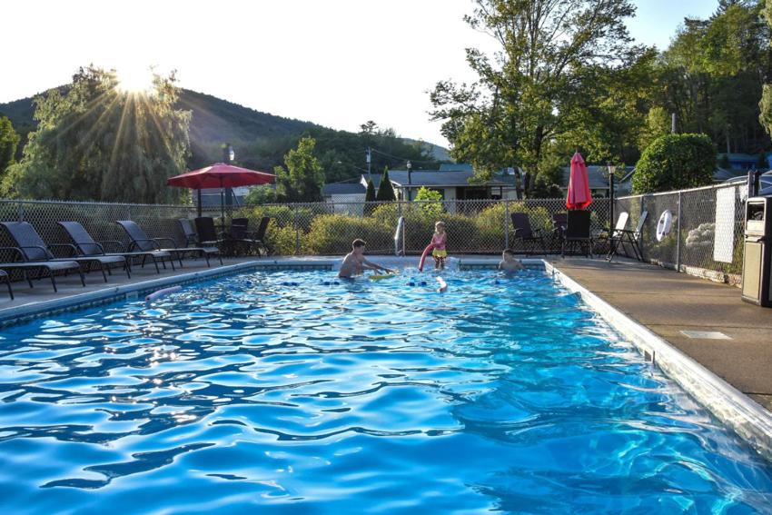 a man and a child playing in a swimming pool at Adirondack Sunrise Lodge in Lake George
