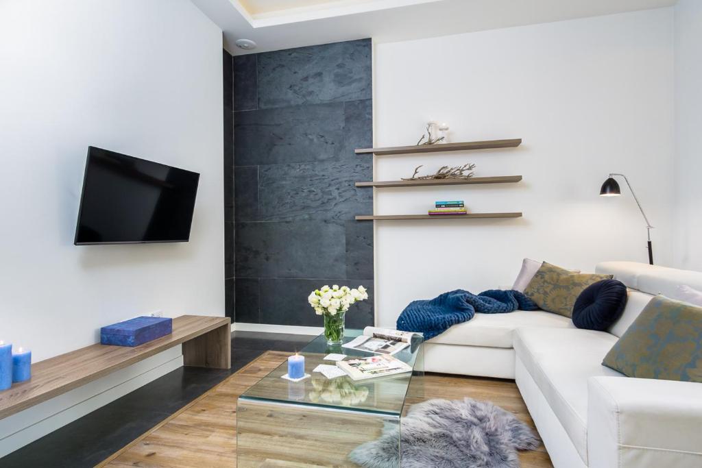 ソポトにあるElite Apartments Sopot Premiumのリビングルーム(白いソファ、テレビ付)