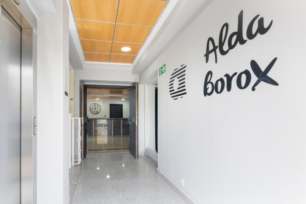 un couloir d'un bâtiment avec une pancarte sur le mur dans l'établissement Hotel Alda Borox, à Borox