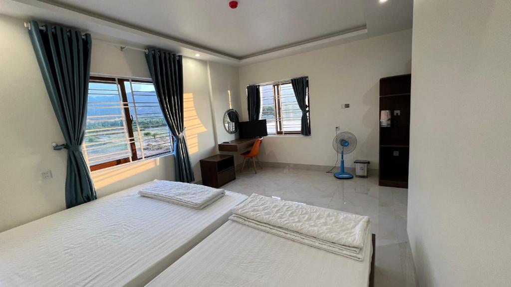 um quarto com 2 camas e uma janela em Khách sạn Thiên Minh - Dốc Lết em My Luong