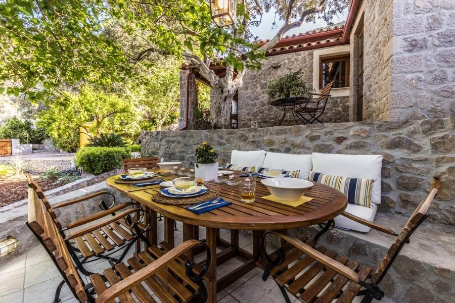 einen Holztisch und Stühle auf einer Terrasse in der Unterkunft Rodia Eco stay house in Epidavros - Akros Estate in Nea Epidavros