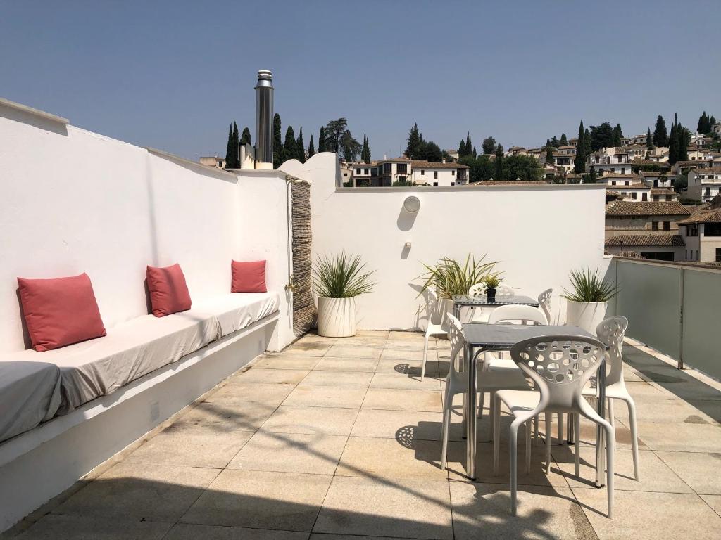 a patio with a table and chairs on a roof at Amazing Loft! Rooftop Terrace! Alhambra Views! in Granada