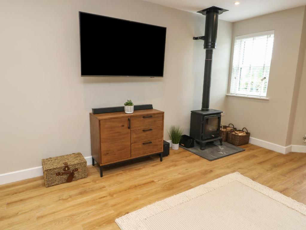 a living room with a tv and a wood stove at Bay Tree Cottage in Caernarfon