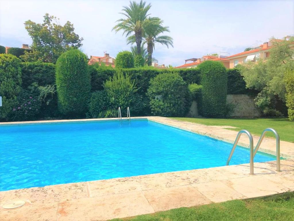 una gran piscina azul en un patio en Apartamento en Platja Sant Pol S'agaro con pisicina y jardin (playa - centro), en Sant Feliu de Guíxols