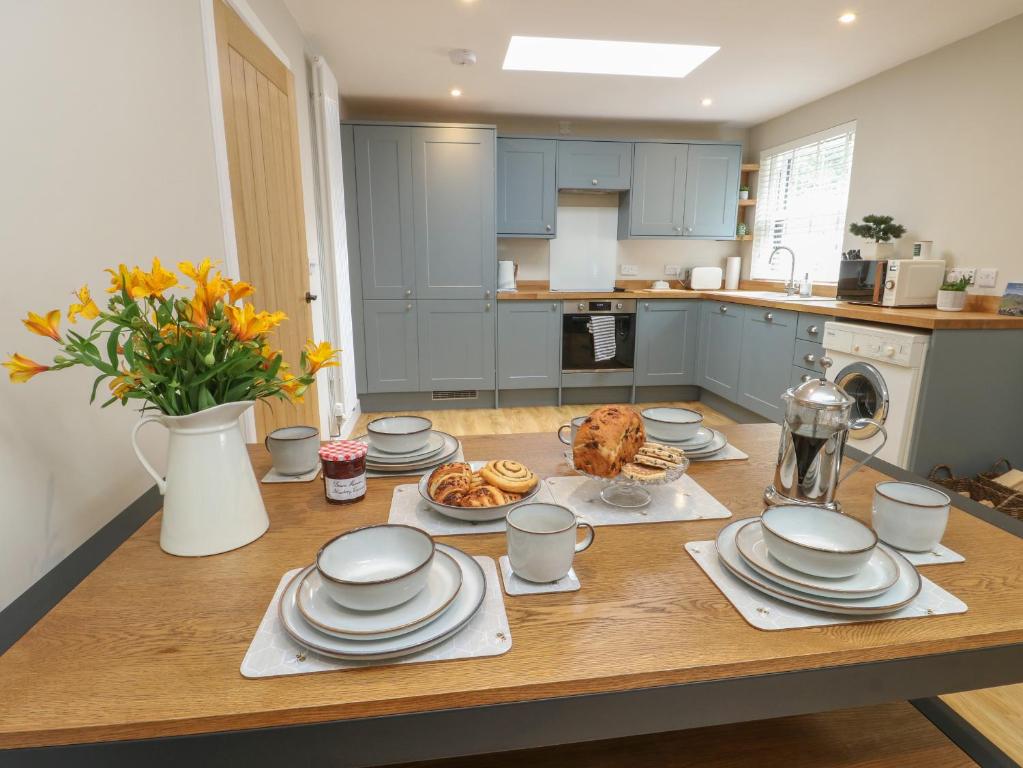 a kitchen with a table with plates of food on it at Fir Tree Cottage in Caernarfon