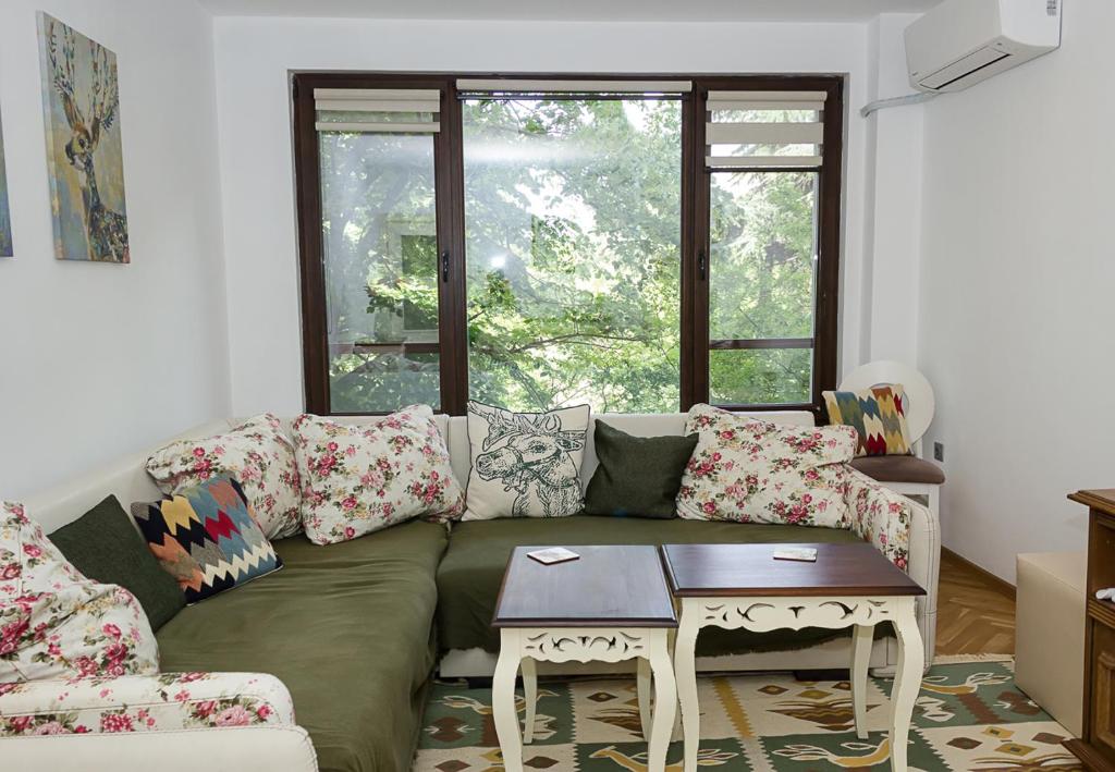 un soggiorno con divano e tavolo di Chayka Charm Cozy 1BD Apartment in Varna a Varna