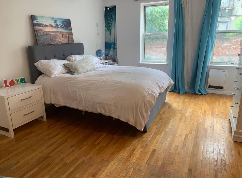 a bedroom with a bed and a wooden floor at Crown Heights Gem in Brooklyn