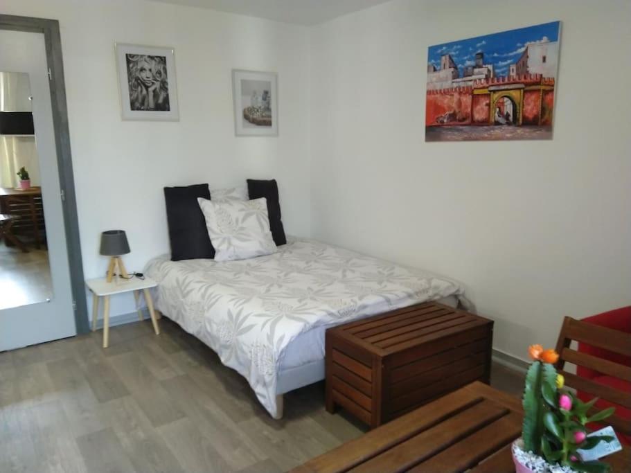 - une chambre avec un lit, une table de chevet dans l'établissement Arbois: très beau studio place de la Liberté, à Arbois