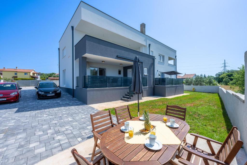 a patio with a table and chairs in front of a house at Domus Alba Apartments in Pula