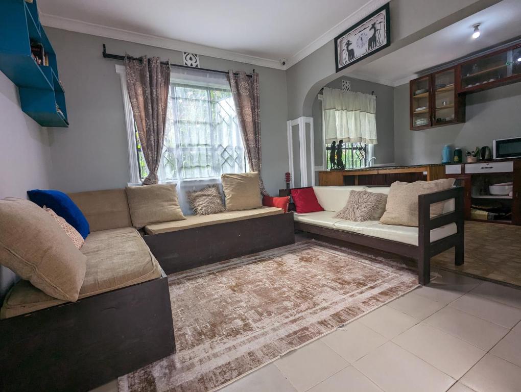 Elizabeth Home في أروشا: غرفة معيشة مع أريكة وطاولة