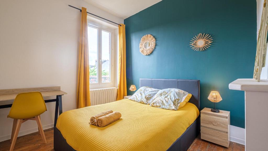 - une chambre avec un lit jaune et un mur bleu dans l'établissement Les Cheminées - Welc'Home, à Limoges