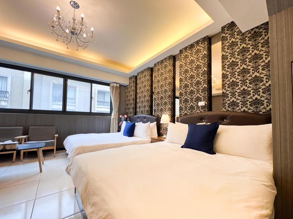 um quarto de hotel com duas camas e um lustre em 一中小窩馨 em Taichung