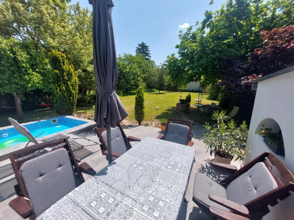 a patio with a table and chairs and a pool at Bajcsyház Apartman in Keszthely