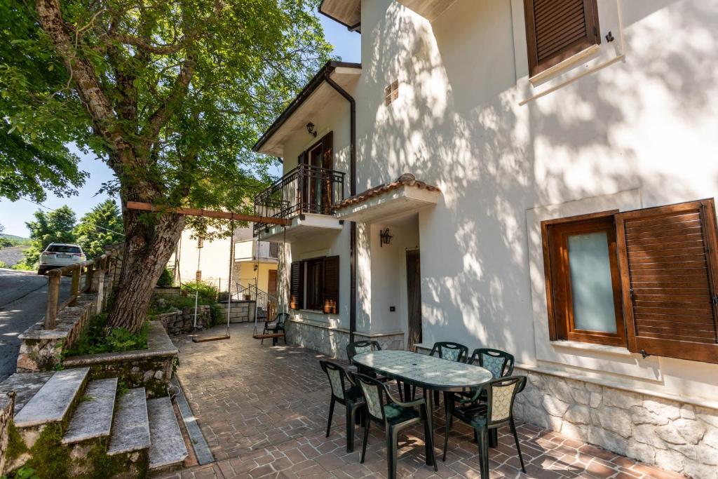 un patio con mesa y sillas junto a un edificio en Casa vacanze “Le noci” en SantʼEufemia a Maiella