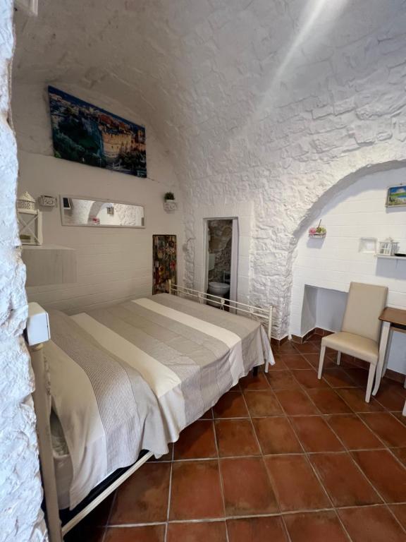 a bedroom with a bed and a table and a chair at Casa Il Rosone in Carovigno
