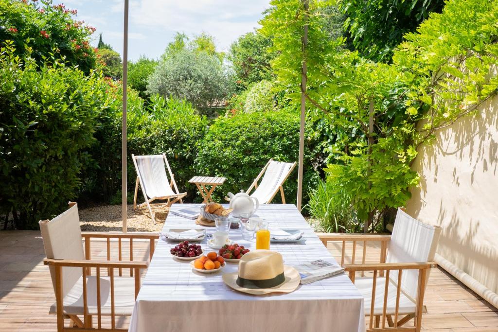 una mesa con platos de comida en el patio en Les Canisses, magnifique appartement avec terrasse au cœur d'Uzès, en Uzès