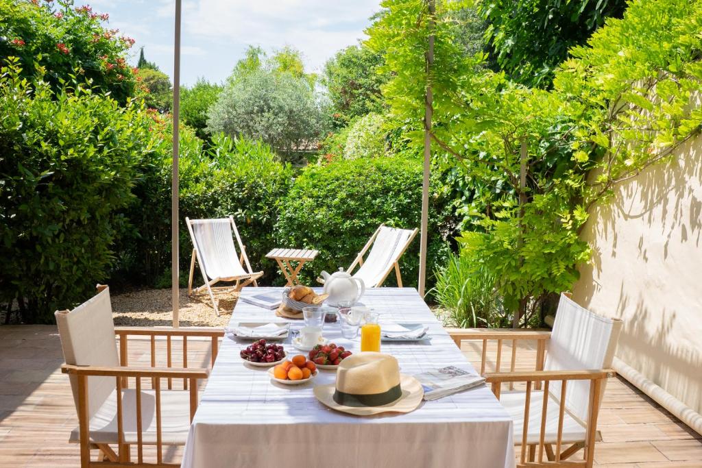 - une table avec des assiettes de nourriture sur une terrasse dans l'établissement Les Canisses, magnifique appartement avec terrasse au cœur d'Uzès, à Uzès