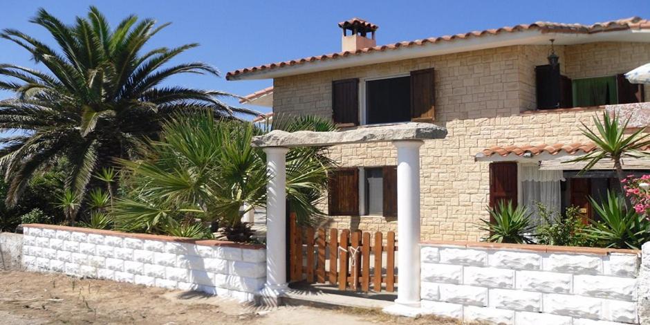 a house with a fence and a palm tree at Villaliana in Torre Dei Corsari