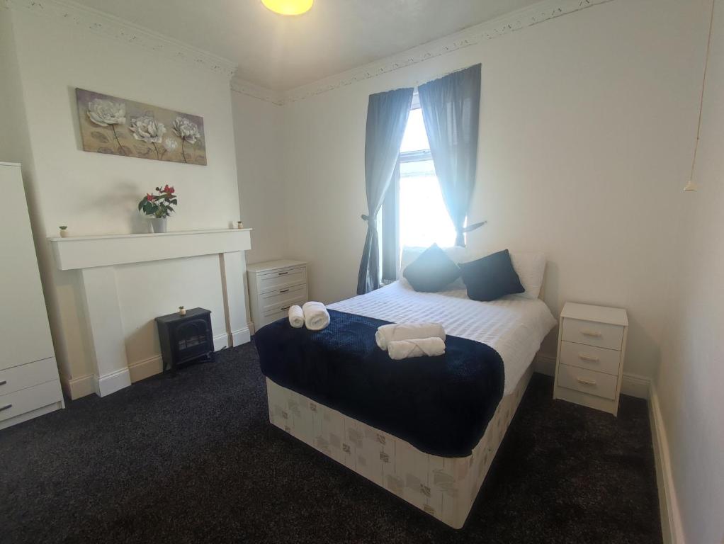 a bedroom with a bed with blue pillows and a window at A&A Luxury Stay Noble Street in Sunderland