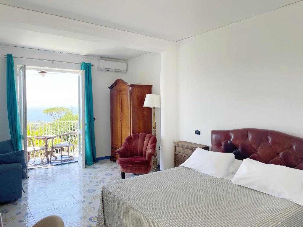 sypialnia z łóżkiem i krzesłem oraz balkon w obiekcie Villa Giovanna w Sorrento