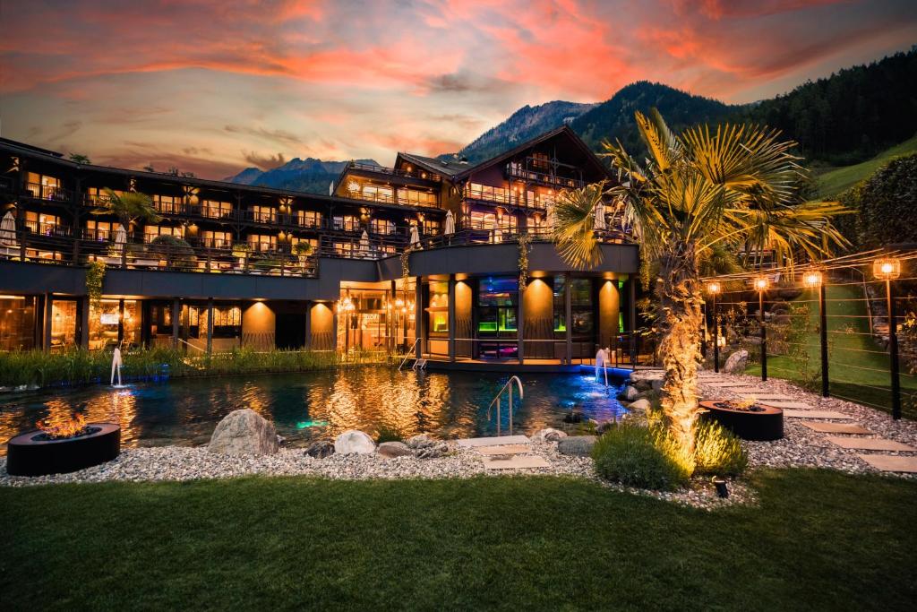 a large building with a pond in front of it at Andreus Resorts in San Leonardo in Passiria