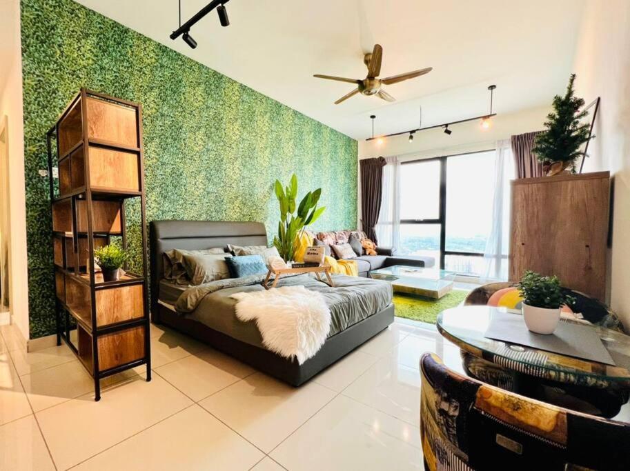 uma sala de estar com uma cama e um sofá em Tropical Style @JB Mosaic(HighFloor)10-13pax 65'TV em Johor Bahru