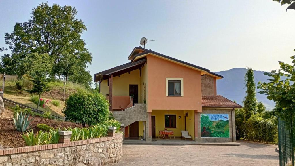 une petite maison jaune avec un mur en pierre dans l'établissement Il Sottobosco, à Satriano di Lucania