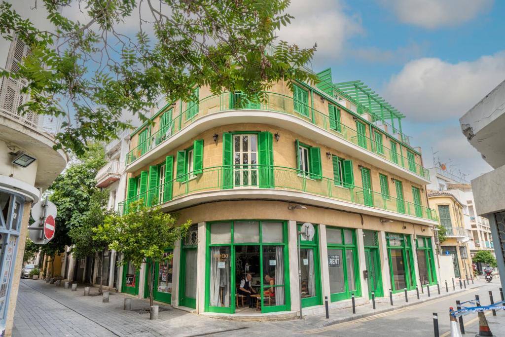 a green and yellow building on a street at Private room in shared flat in Nicosia