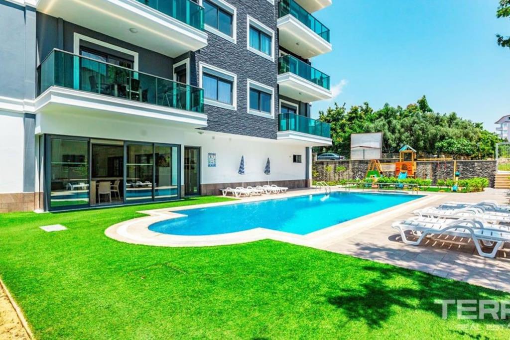 a house with a swimming pool and a yard at Sea Pearl flat in Avsallar