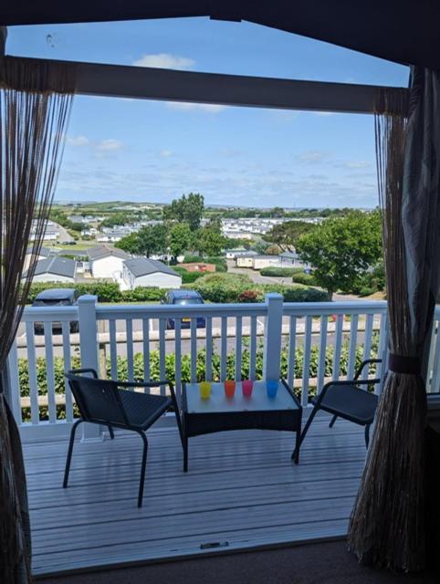 a porch with a bench and chairs on a balcony at Panoramic Views Relaxing Caravan Littlesea Haven Weymouth in Weymouth