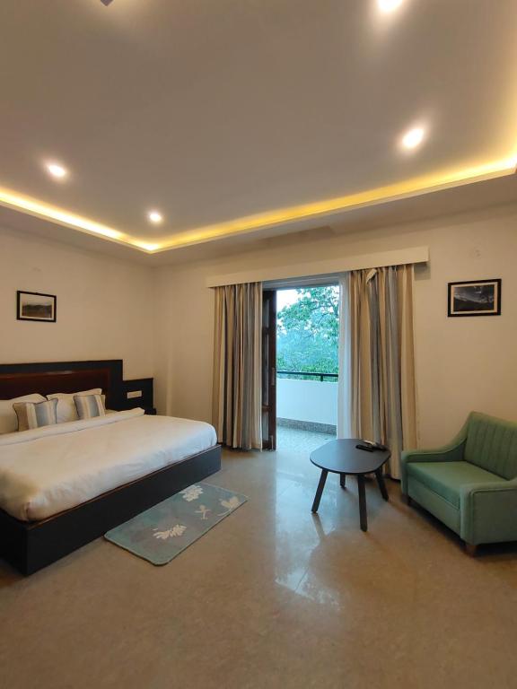 een slaapkamer met een bed, een stoel en een raam bij The Garuda Hotel And Spa in Gangtok