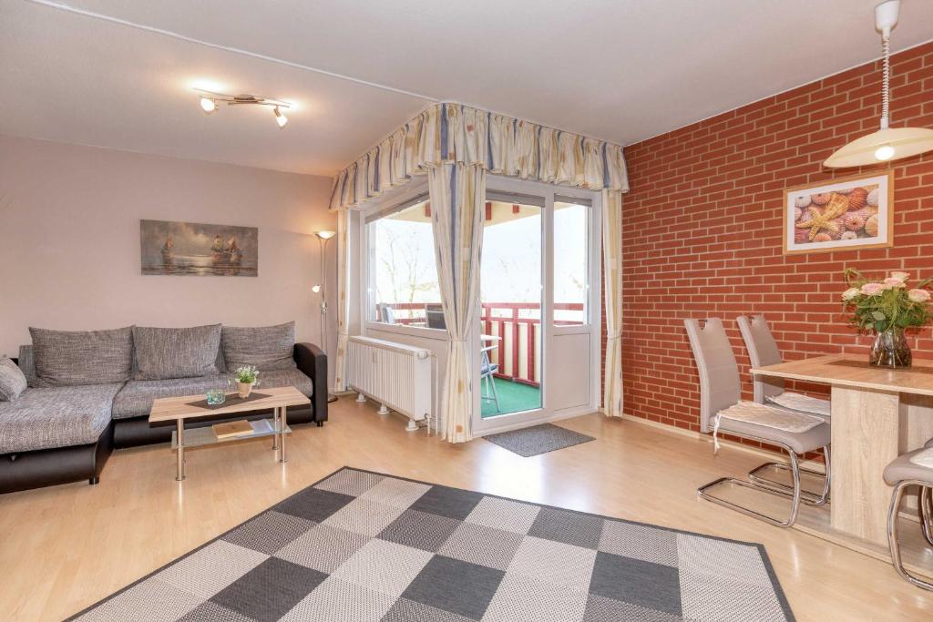 a living room with a couch and a brick wall at Terrassenhaus, FeWo 19 in Duhnen