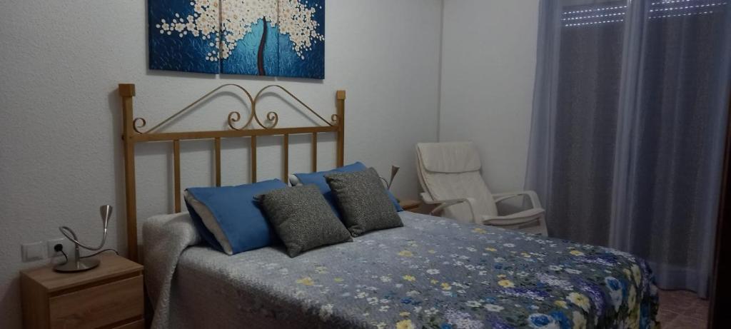 a bedroom with a bed and a chair in it at Apartamento Sevilla 3 in La Guardia