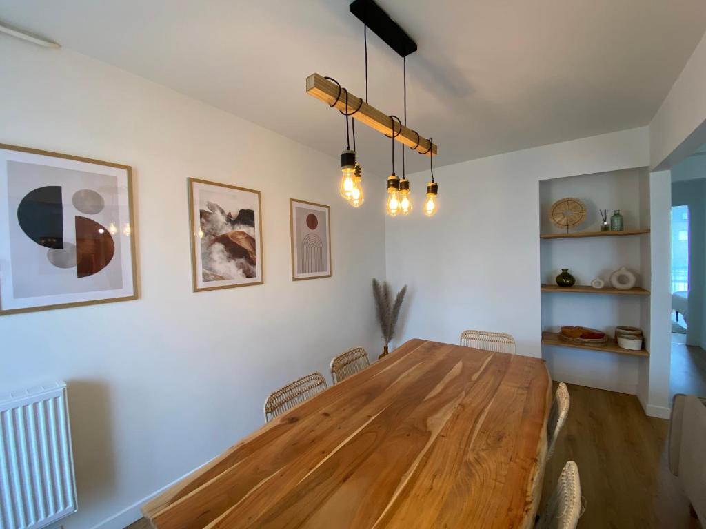 - une salle à manger avec une table et des chaises en bois dans l'établissement La Coloc' - Centre ville - Gare, à Saint-Brieuc