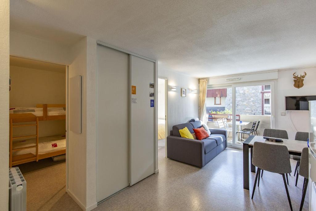 a living room with a couch and a table at Appt 4 pers tout équipé hypercentre village fibre garage draps fournis in Saint-Lary-Soulan