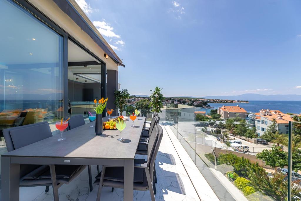 a dining table on a balcony with a view of the ocean at Apartment Magdalena in Malinska