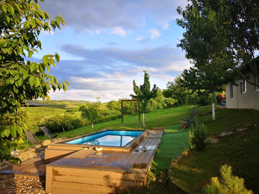 uma piscina num quintal com um deque de madeira em Sami Green House em Banoštor