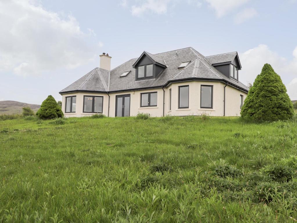 une maison sur une colline avec de l'herbe verte dans l'établissement Challenger Lodge, à Lairg