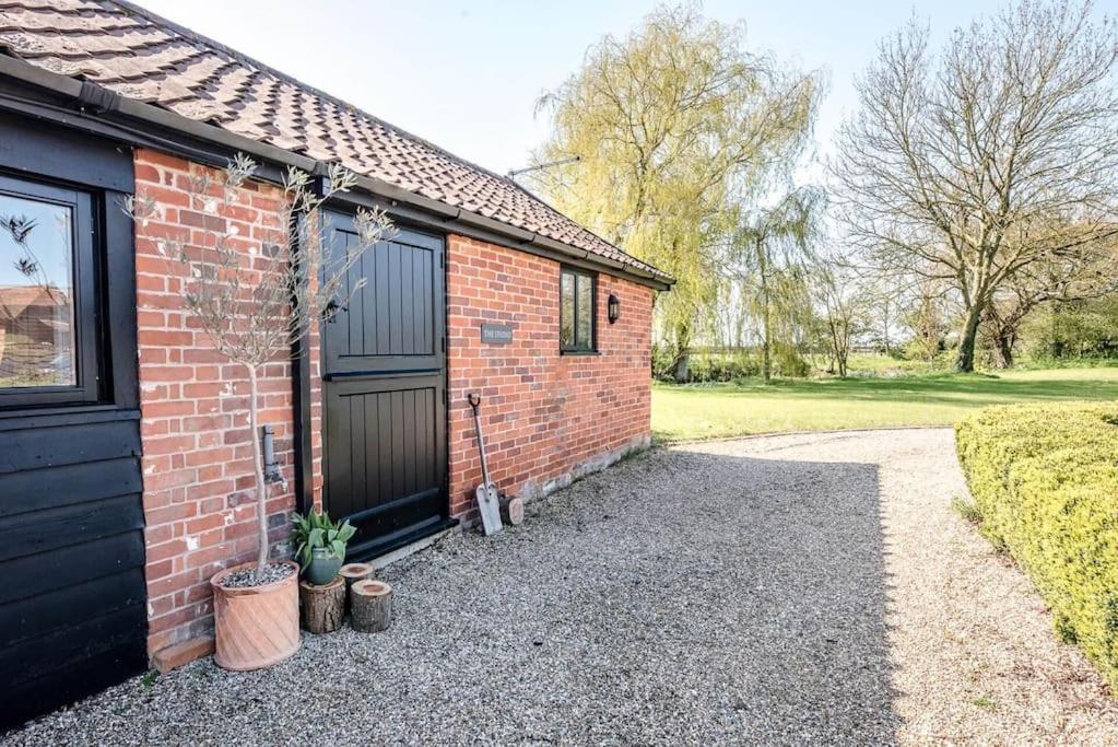 a brick house with a garage and a driveway at The Studio, Hoo in Woodbridge