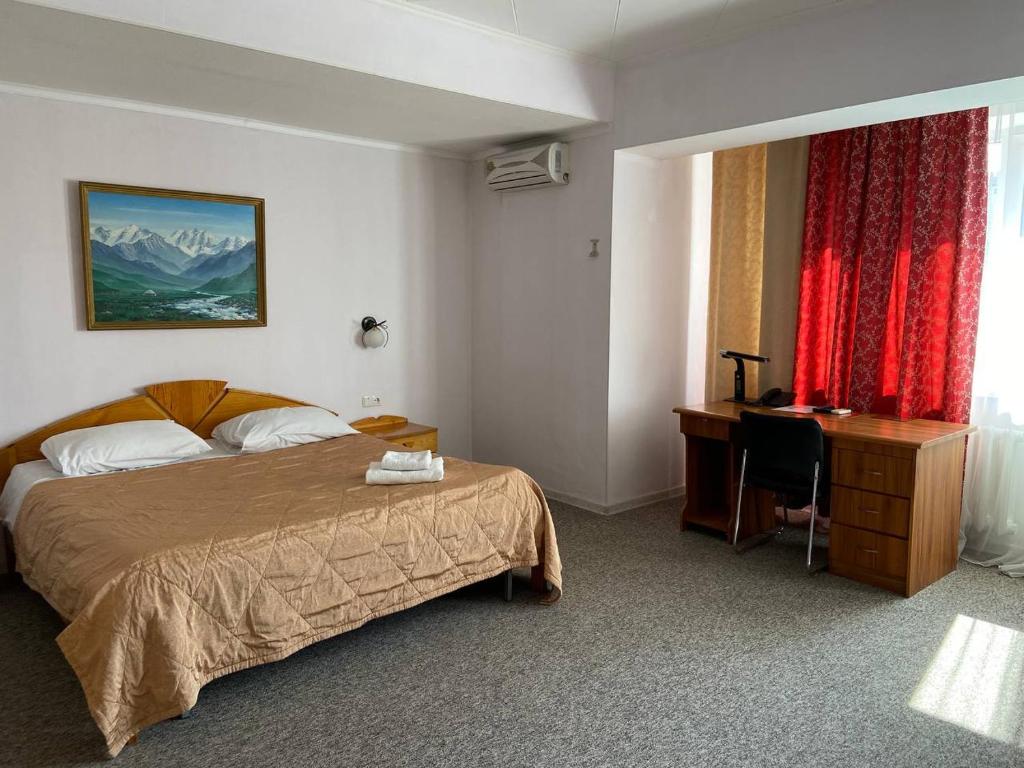 a hotel room with a bed and a desk at Silk Road Lodge in Bishkek