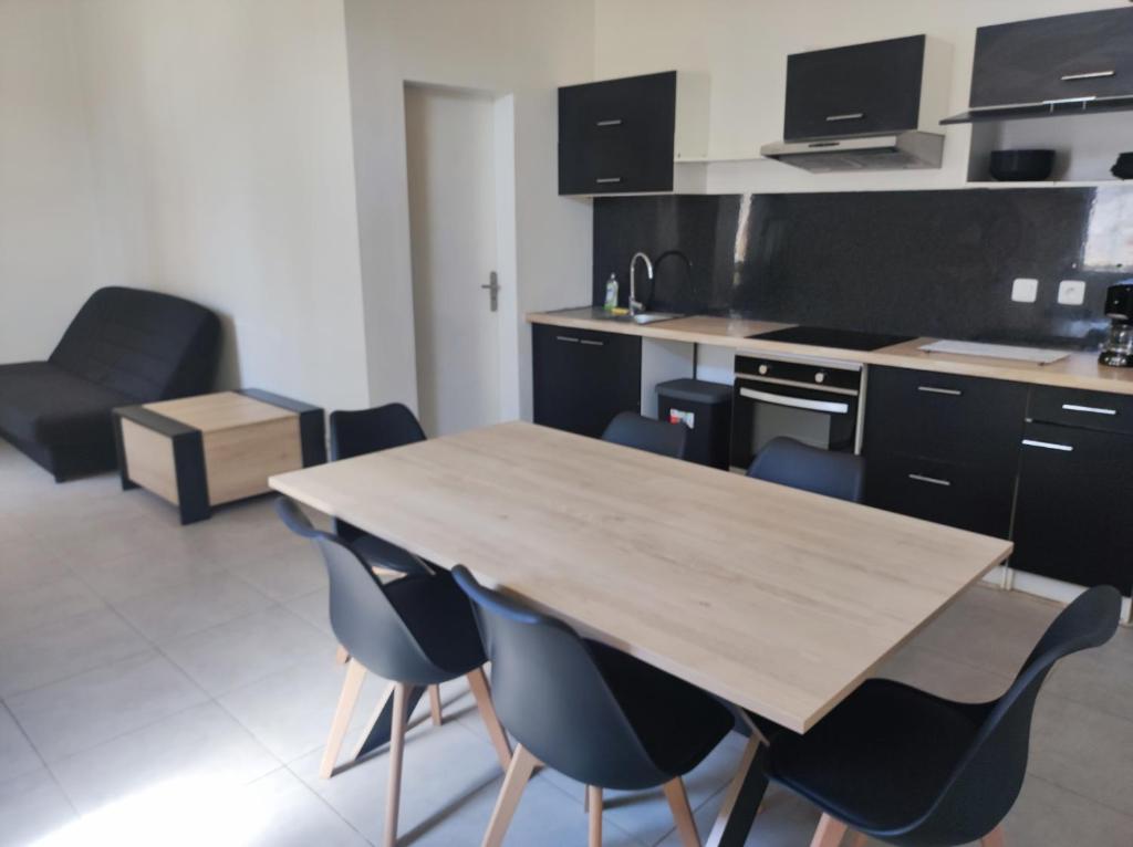 eine Küche mit einem Holztisch und Stühlen in der Unterkunft appartement dans partie de mas en camargue in Arles
